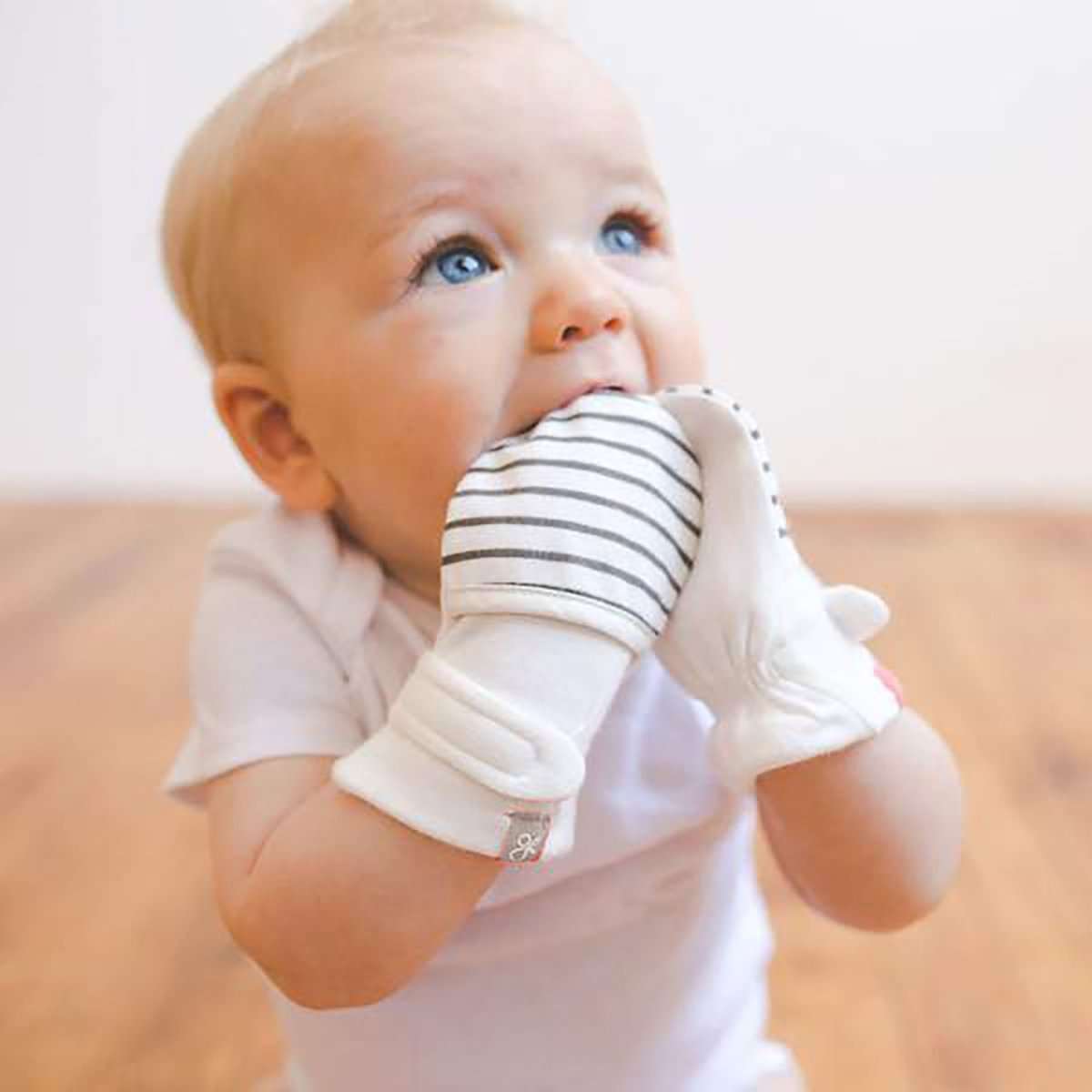 2-PACK MITTS in soft white with gray horizontal stripes and solid white cuffs, worn by a baby