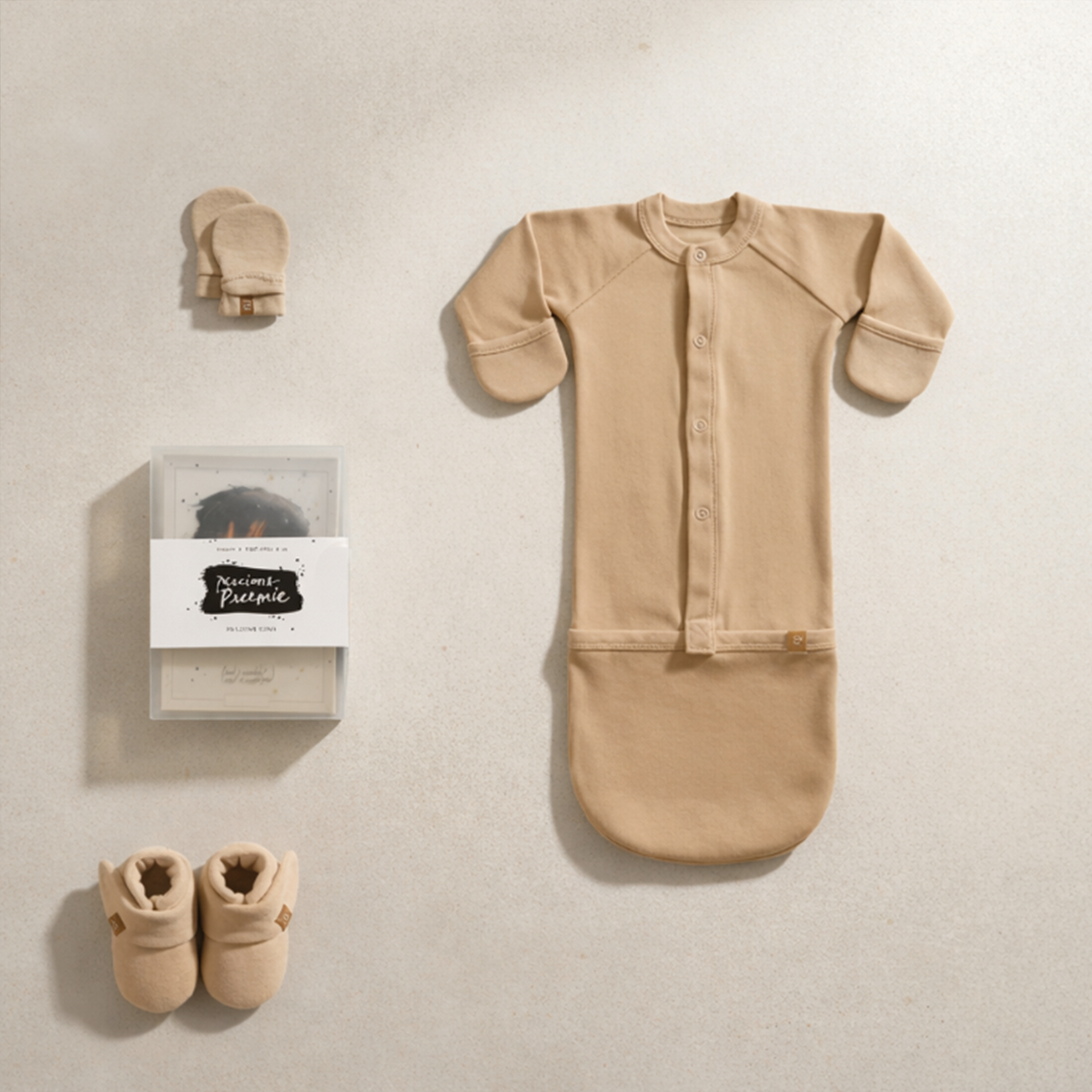 Preemie Sleep Set in sand-colored bamboo-cotton fabric, with a button-front convertible gown, stay-on mitts, boots, and milestone cards.