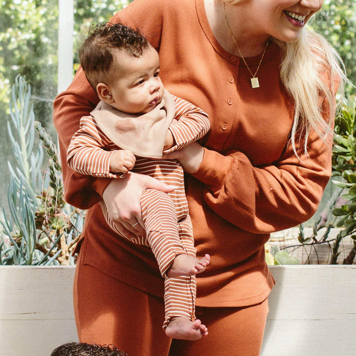 GROW WITH YOU FOOTIE in clay and cream striped bamboo cotton, with long sleeves and convertible foot openings