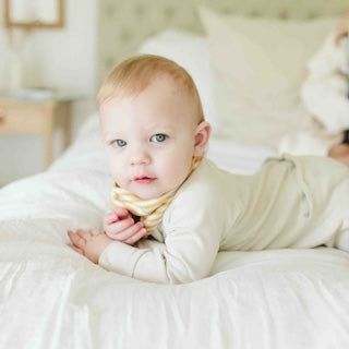 GROW WITH YOU FOOTIE in a solid pale cream, soft-looking footed pajama with long sleeves and a two-way zipper
