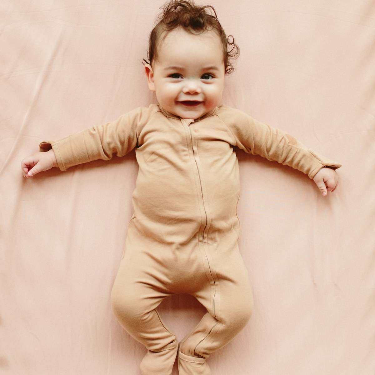 GROW WITH YOU FOOTIE baby romper in sandstone beige, with long sleeves, a front zipper and convertible covered feet