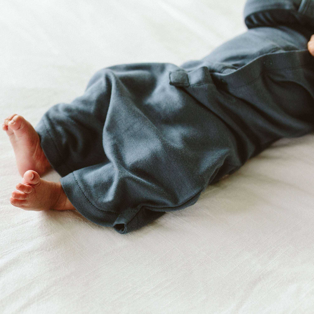 PREEMIE 24 HOUR CONVERTIBLE GOWN in midnight blue, soft solid fabric with a snap detail and covered feet