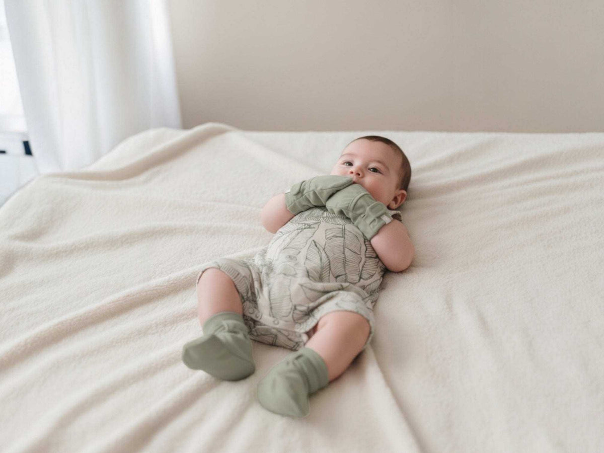 QUICK CHANGE ROMPER in a pale neutral tone with a delicate botanical pattern, short sleeves and leg openings
