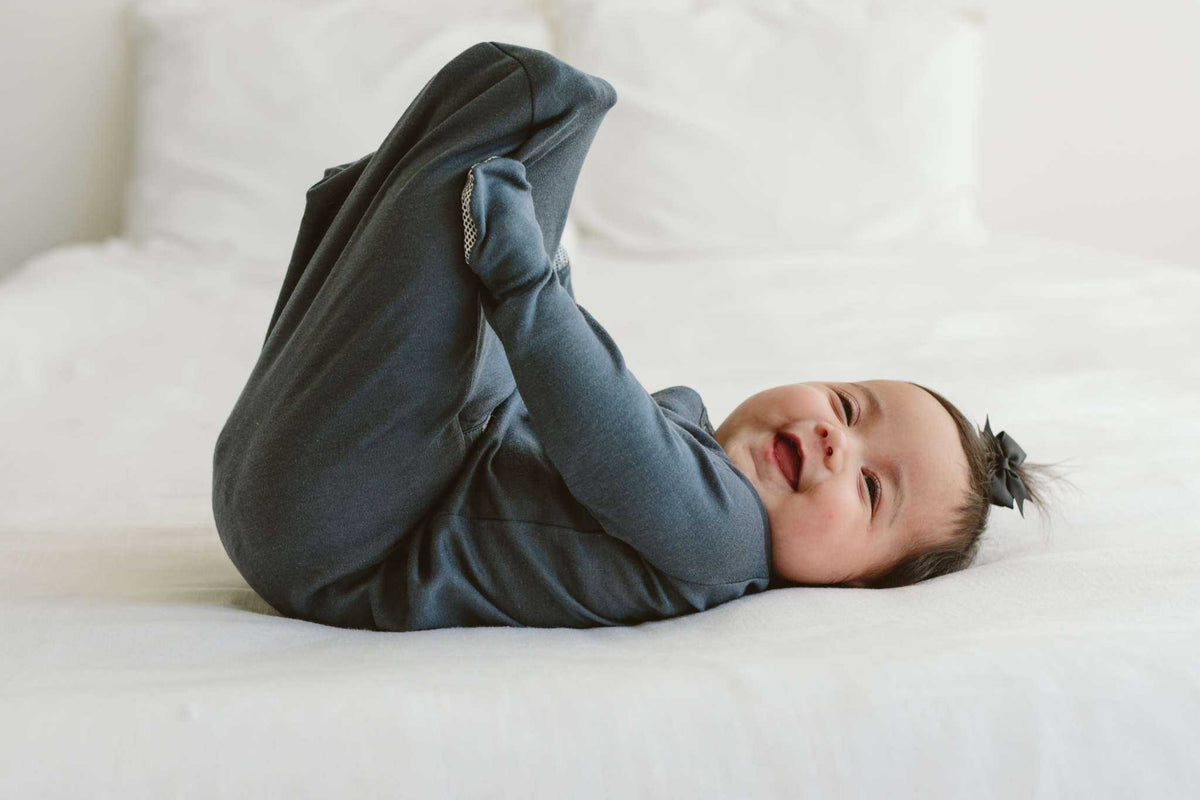 Quiet Night Starter Set with a baby wearing a dark midnight blue, long-sleeved convertible gown with covered feet