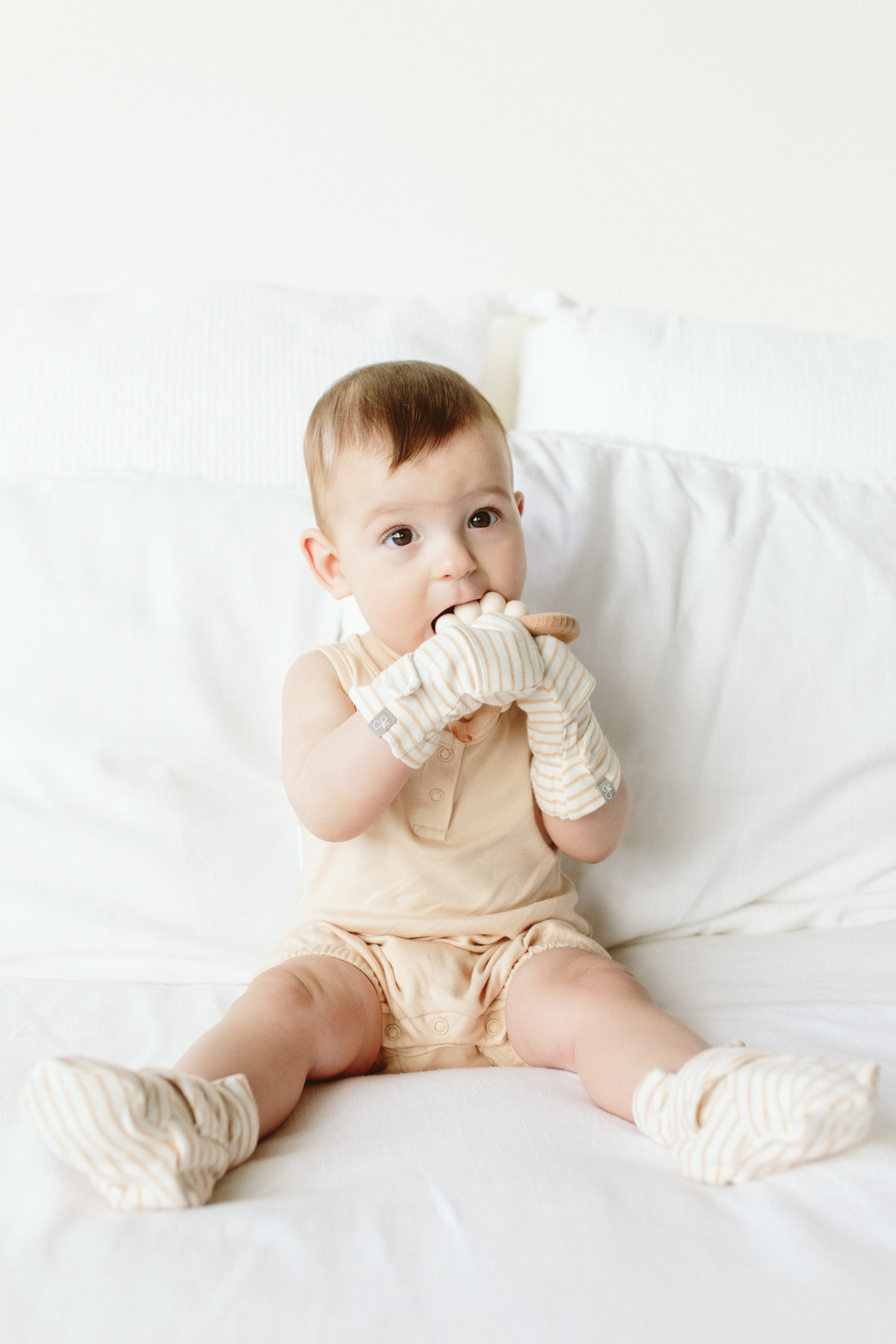 STAY ON 2-PACK BOOTS in soft cream and beige stripes, worn by a baby with a matching adjustable closure