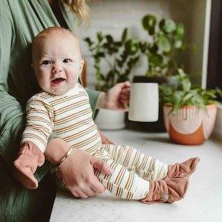 STAY ON 2-PACK BOOTS in dusty rose, soft fabric with gathered ankle cuffs, worn by a baby in striped clothing