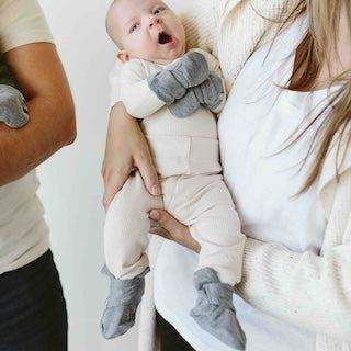 STAY ON 2-PACK MITTS in soft grey and white fabric, shown on a baby with a two-part adjustable closure
