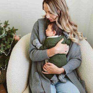 STAY ON 2-PACK MITTS in soft gray fabric with a ribbed cuff, shown on a baby's hands while being held