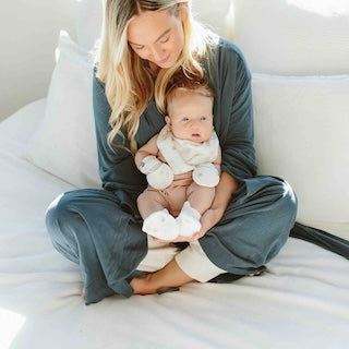 STAY ON 2-PACK MITTS are soft white baby mitts with a subtle black pattern, shown on a baby
