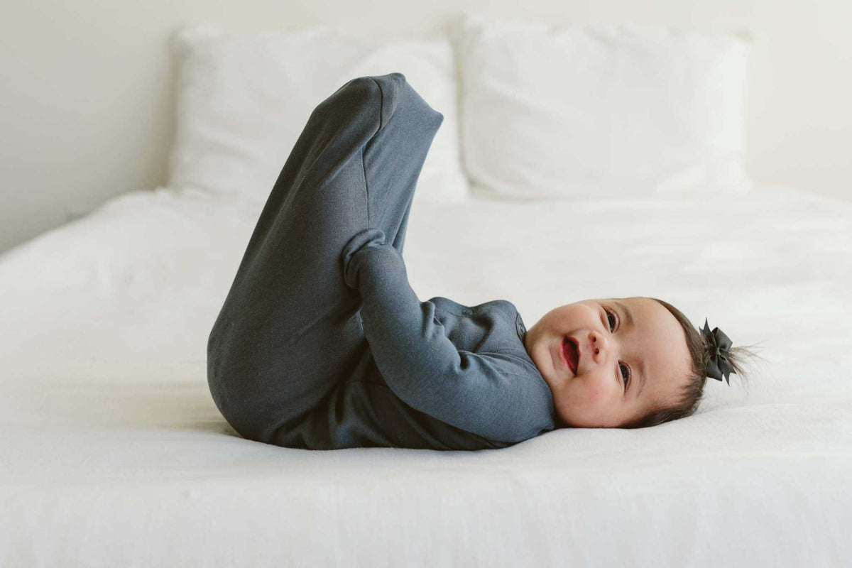 Baby footie from the Welcome Home Set in solid midnight blue, with long sleeves and an enclosed-foot design.