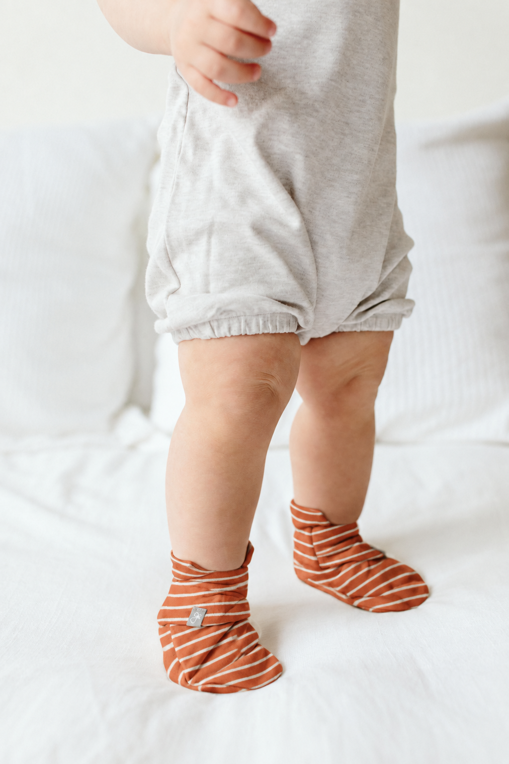 Welcome Home Set baby boots in rust-orange organic cotton with cream stripes and stay-on straps