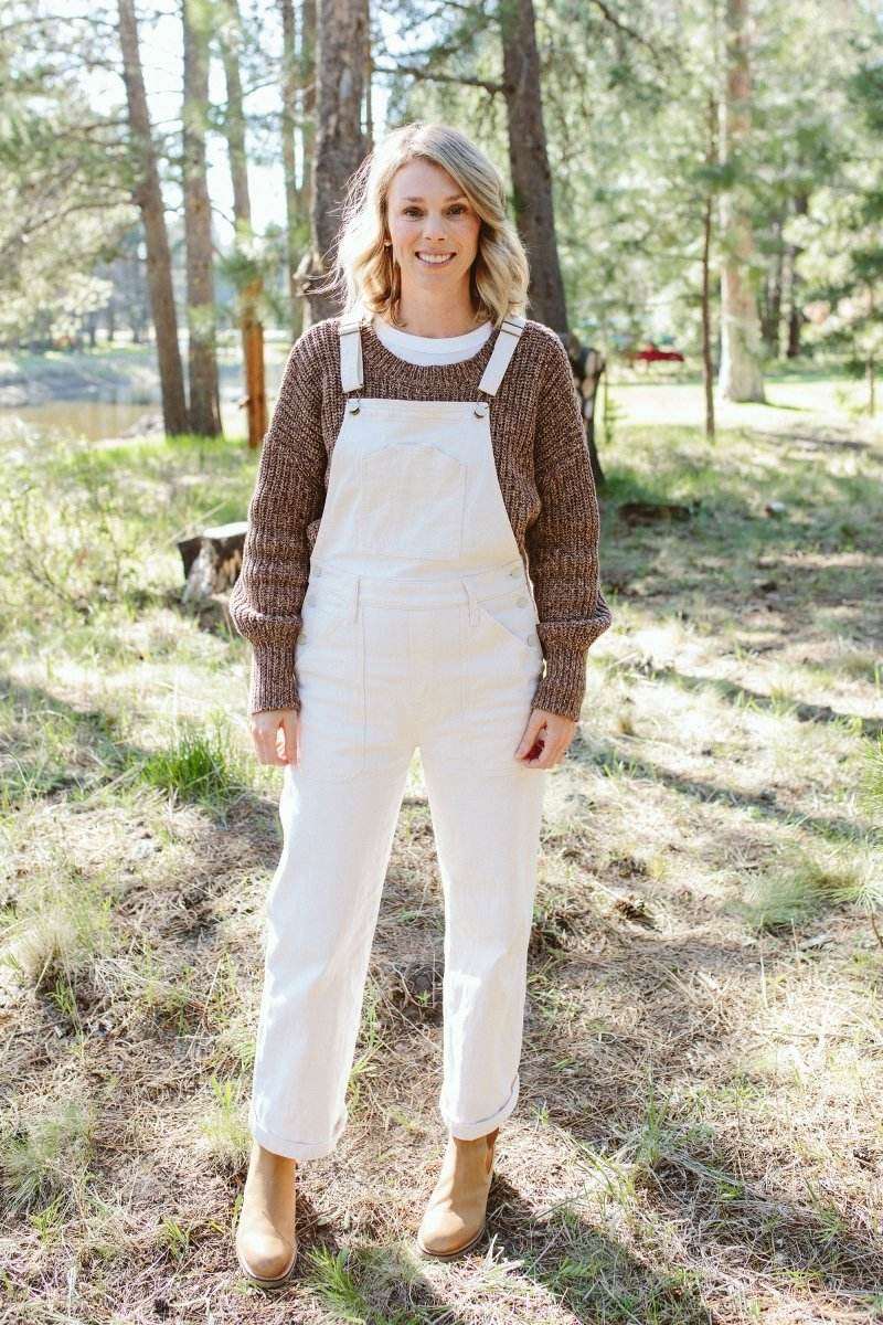 WOMENS CHUNKY KNIT SWEATER in brown organic cotton with a textured knit and relaxed sleeves, worn under white overalls