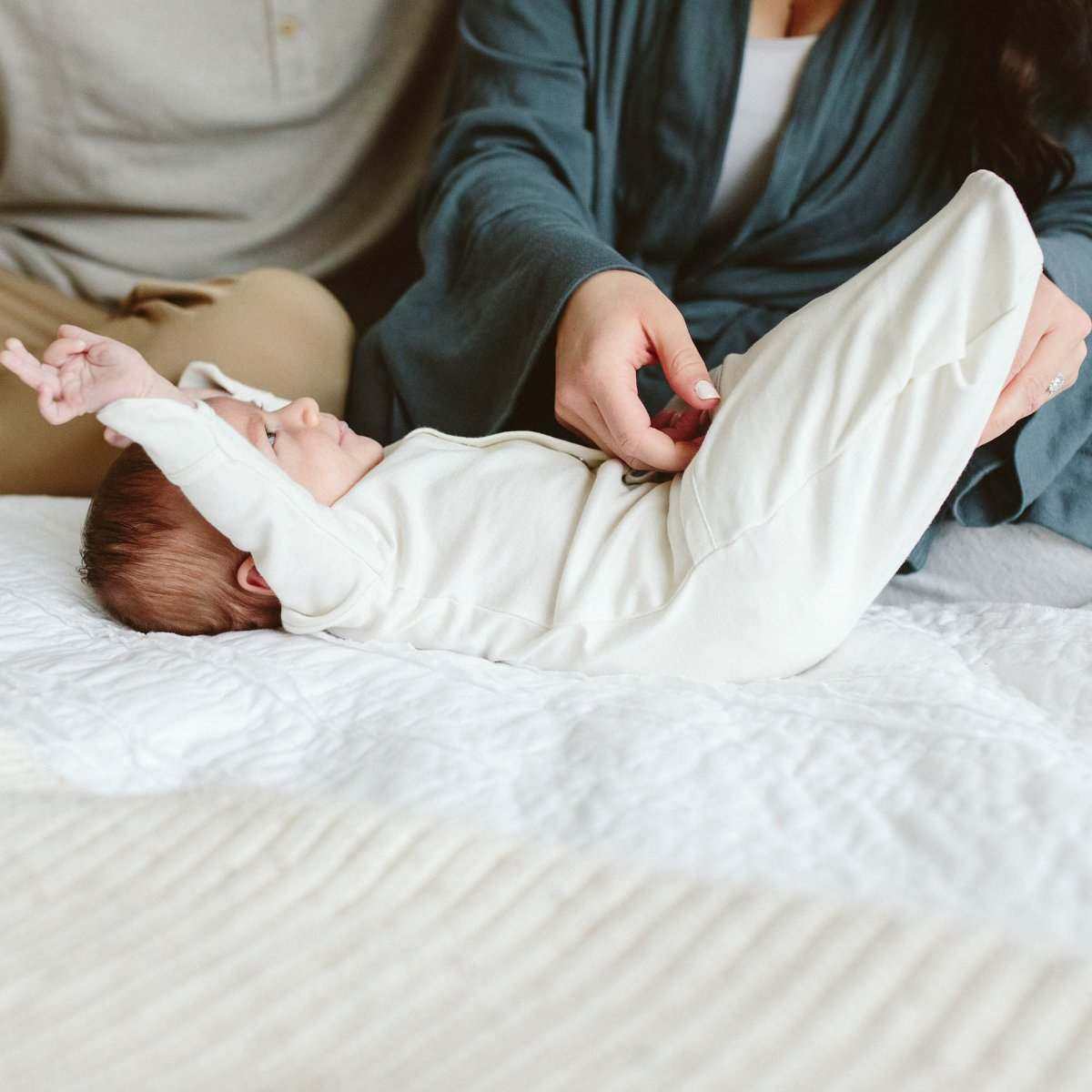 24 HOUR CONVERTIBLE GOWN in soft white fabric, shown on a baby with fold-over mitts and a snap closure