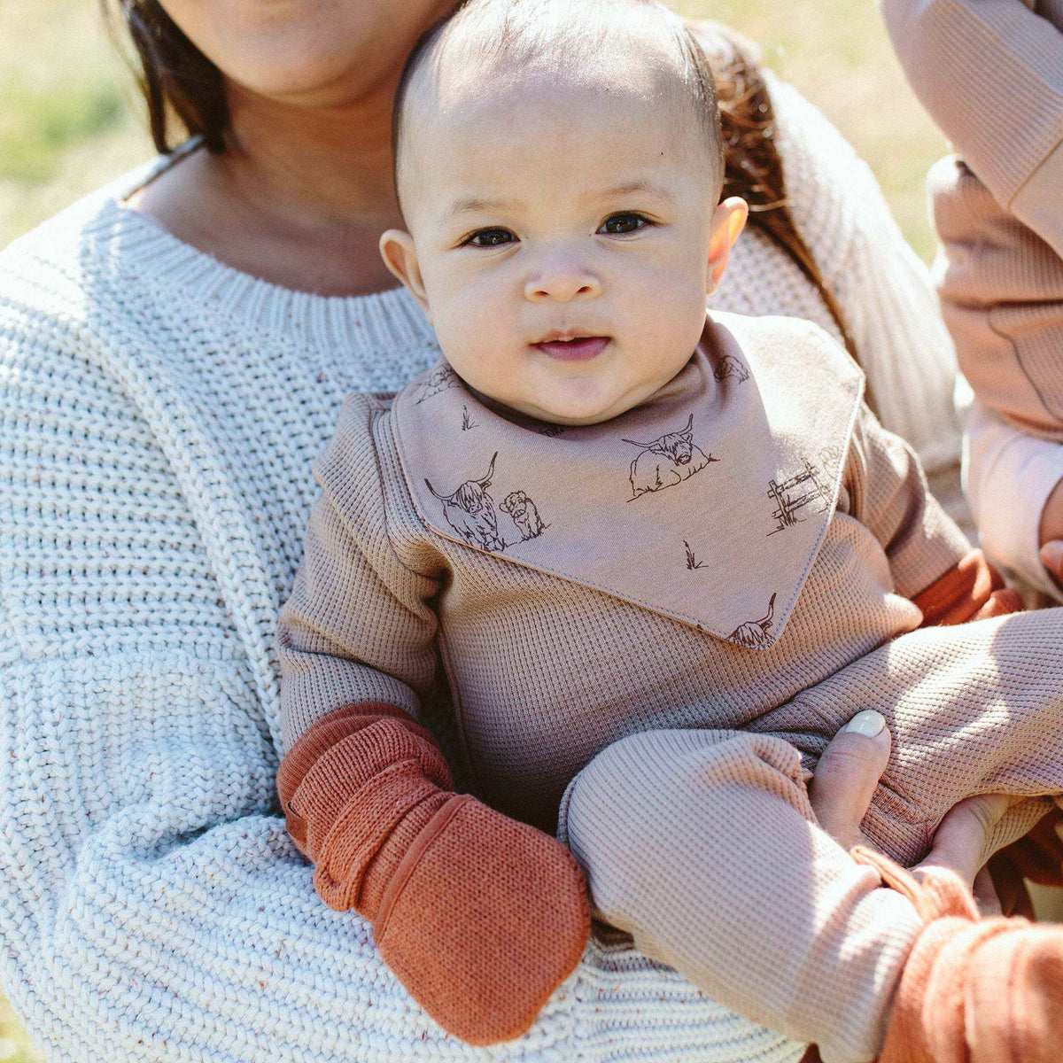 Knit Mitts in clay-colored organic cotton with a chunky ribbed wrist and soft knit texture on a baby