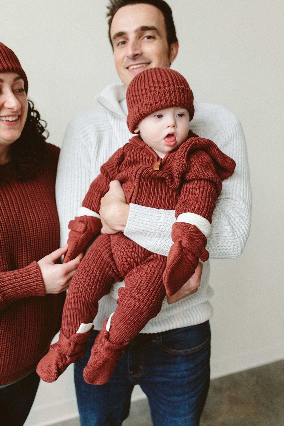 KNIT MITTS in rust-red ribbed knit with white cuff bands, worn by a baby in a matching outfit