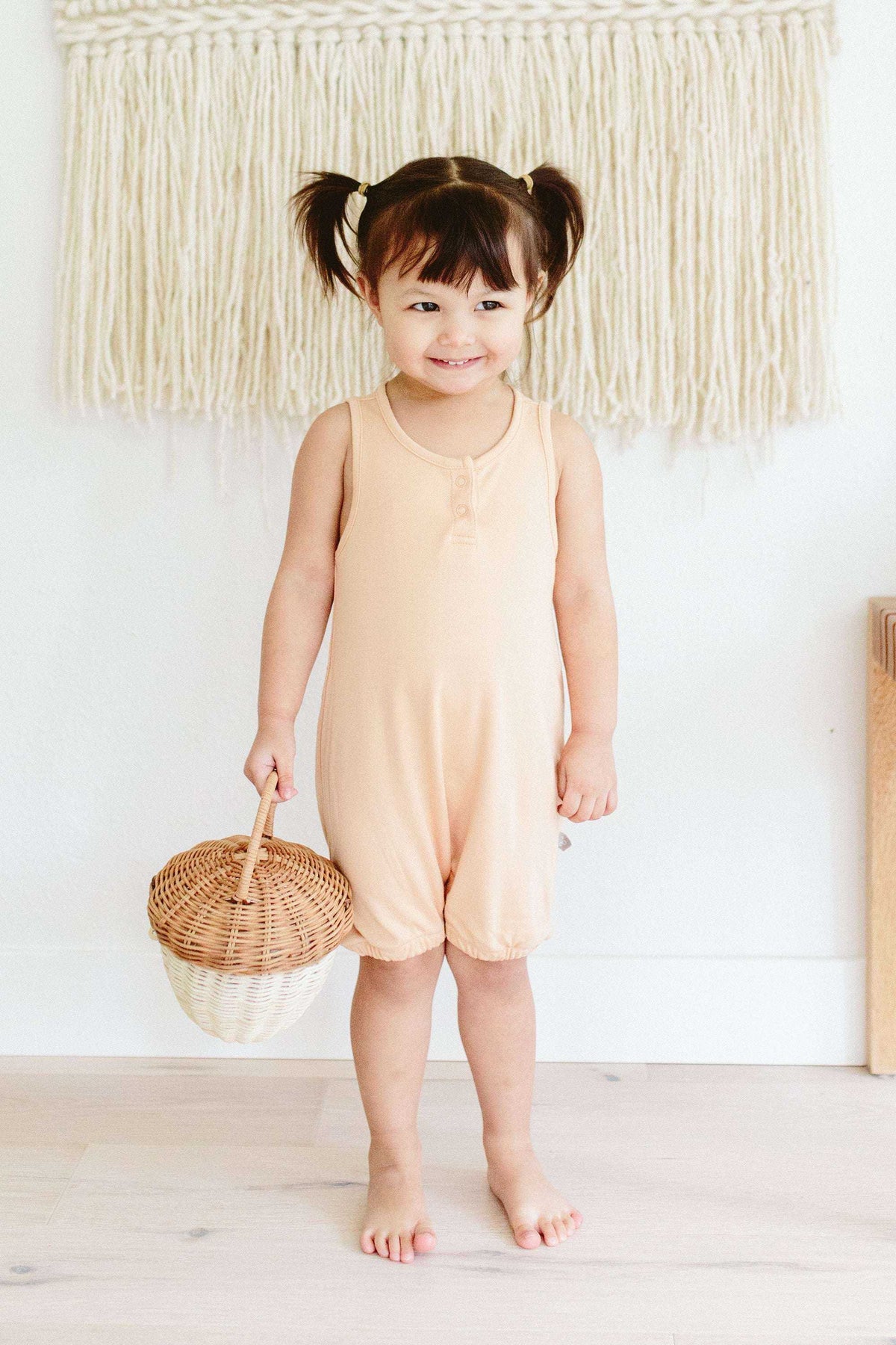 QUICK CHANGE ROMPER in soft peach, with a solid colour, sleeveless cut, scoop neck and snap-front detail