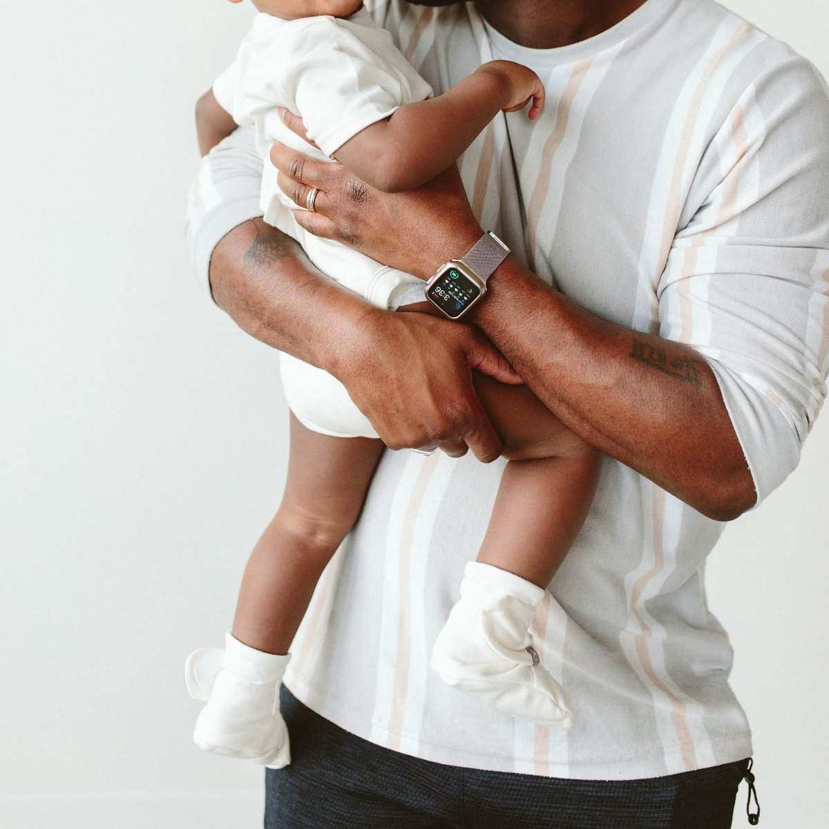 STAY ON BOOTS in soft white fabric, worn by a baby with an adjustable ankle closure