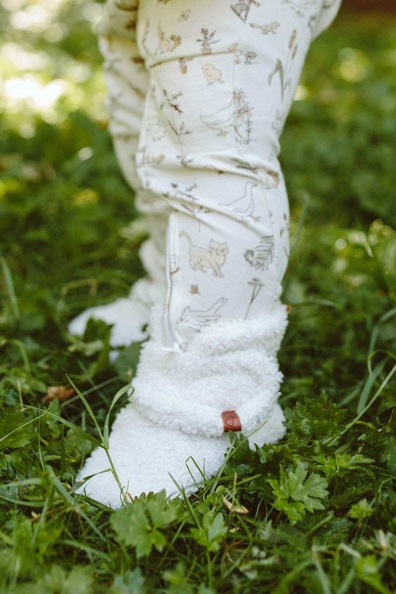 Stay on Sherpa Boots in soft white sherpa fleece, with an adjustable wrap closure and a small tan leather tag